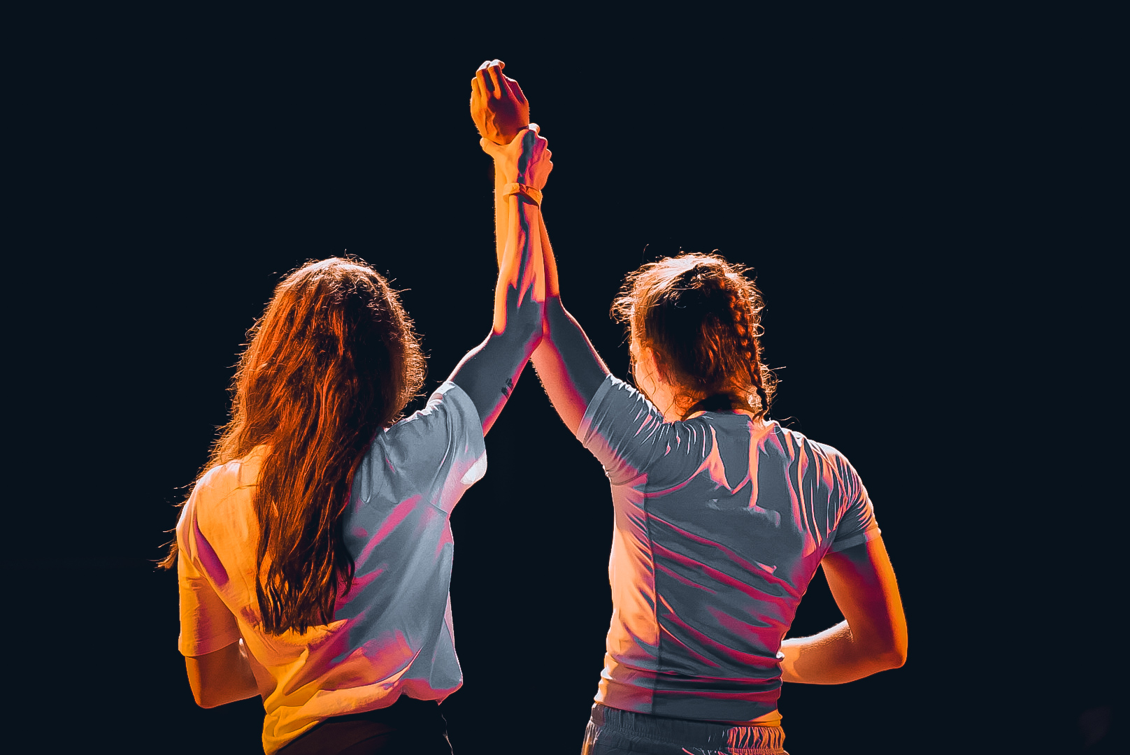 Two women grapplers having their hands raised together after their GrappleMax match