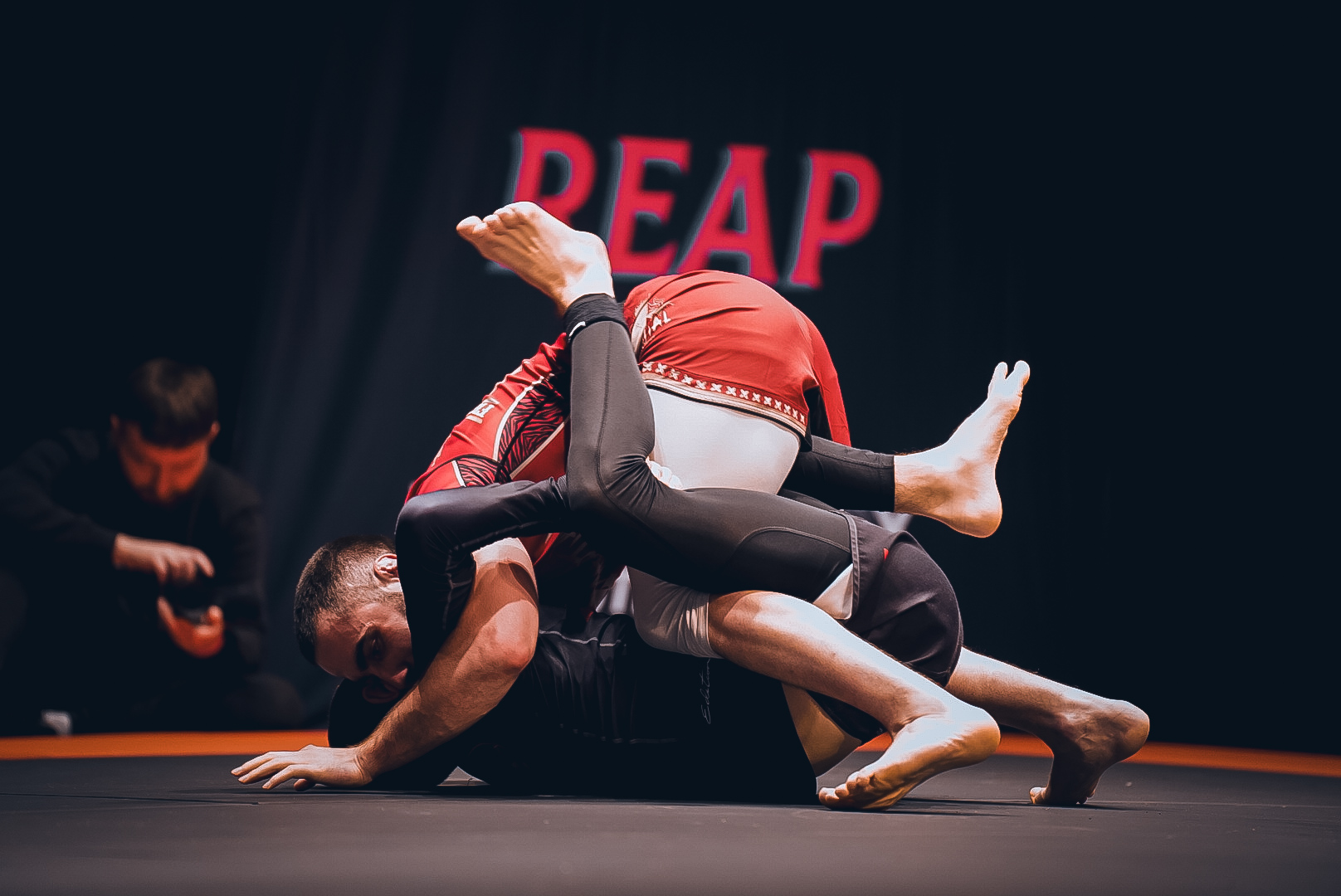 Triangle attack in front of the REAPER stage backdrop at GrappleMax