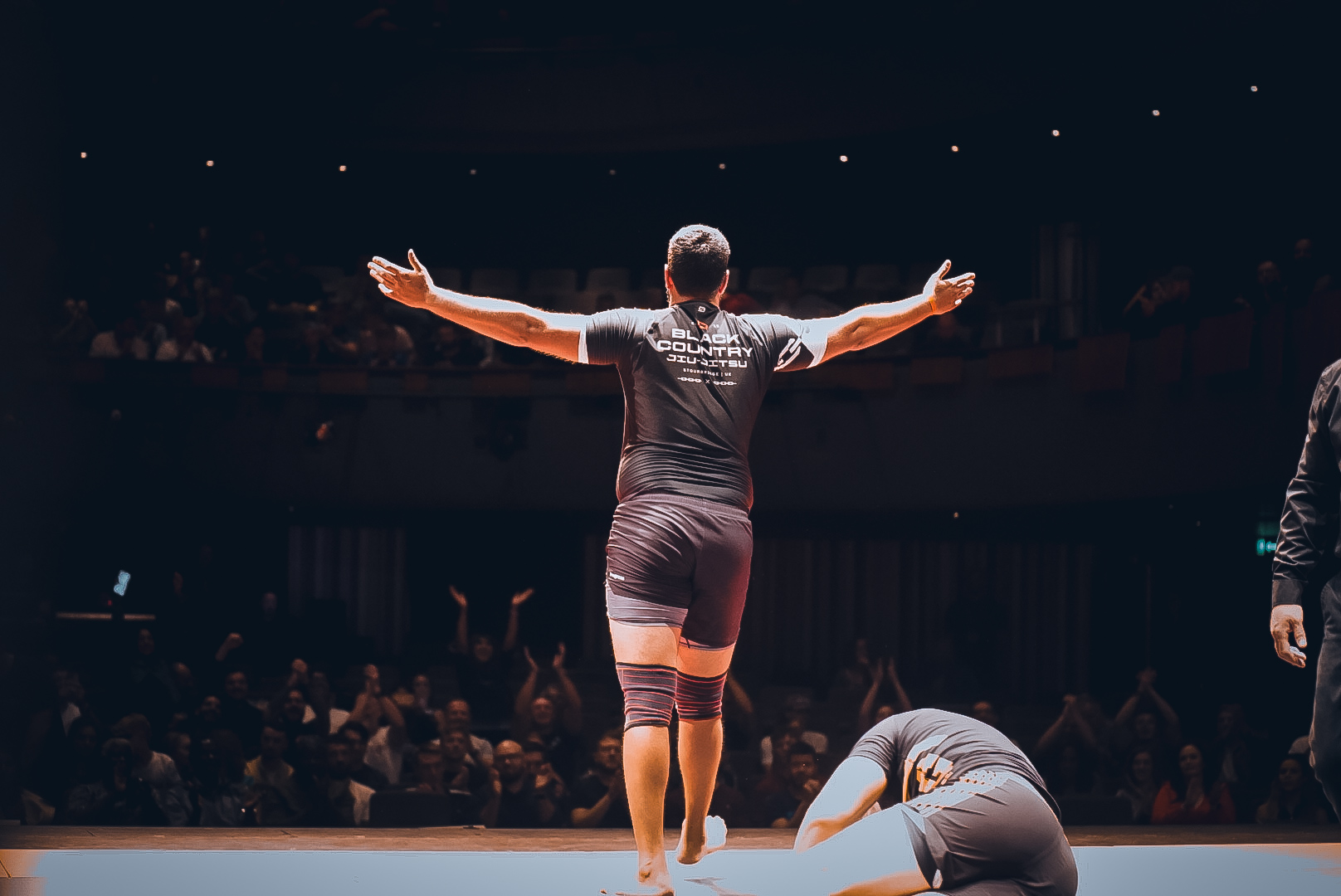 GrappleMax competitor celebrates on stage at Theatre Severn in front of a roaring crowd